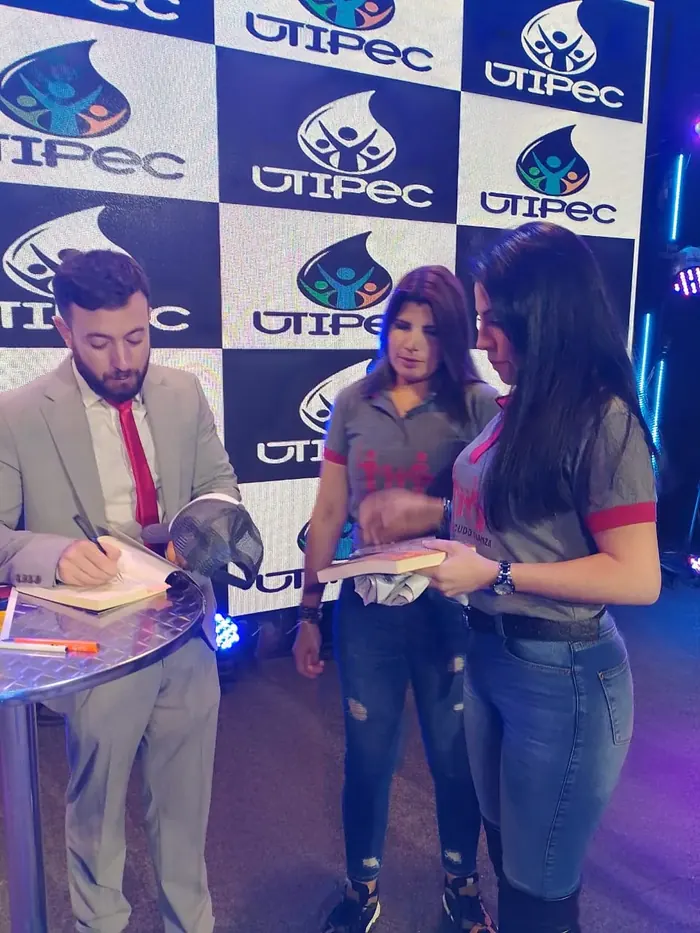 Firma de libros durante una presentación de la Federación
