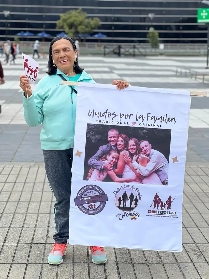 Voluntaria sosteniendo el cartel de la campaña Unidos por las Familias